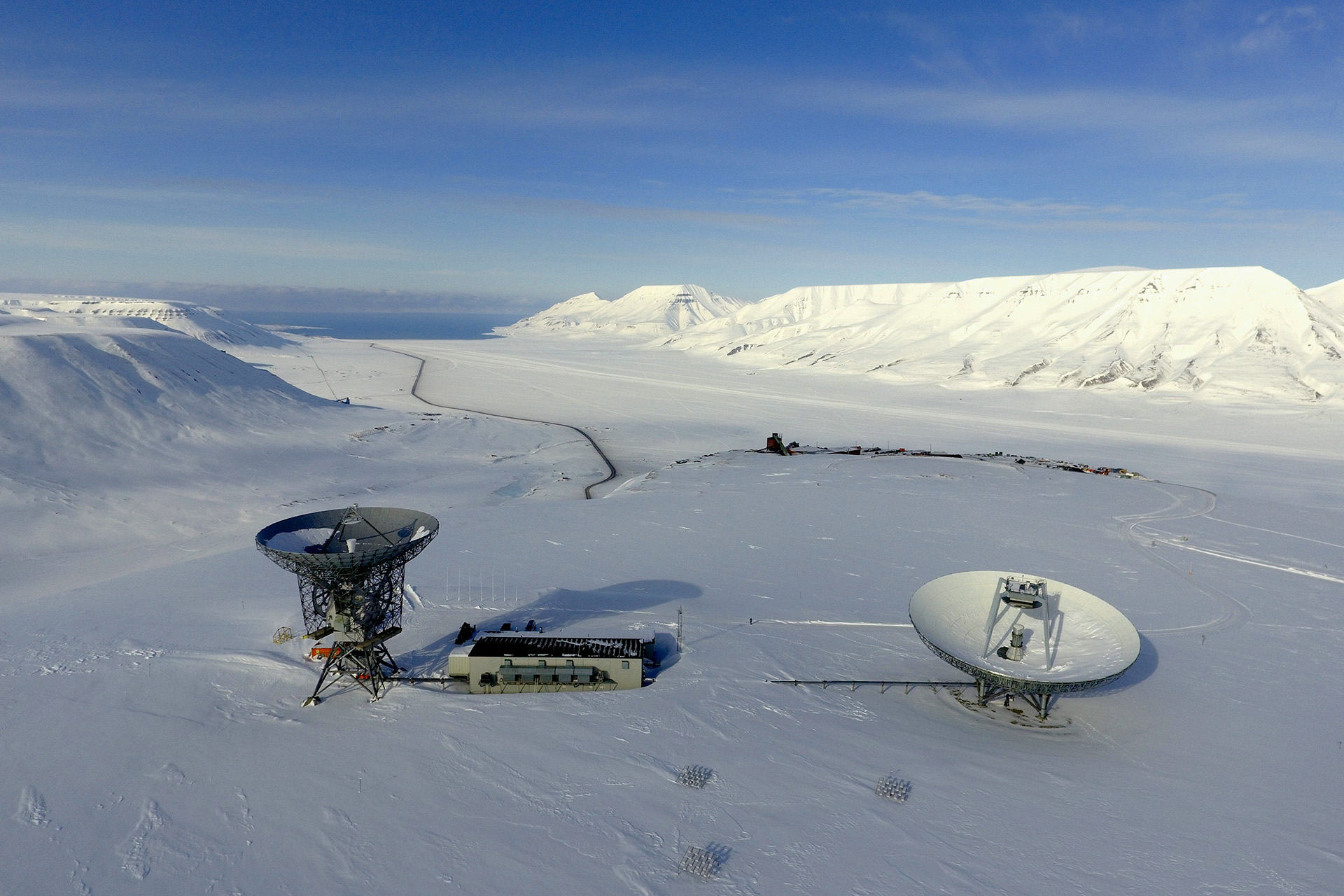 EISCAT Svalbard Radar with the Adventfjorden and the snowy mountains of Svalbard in the background.
