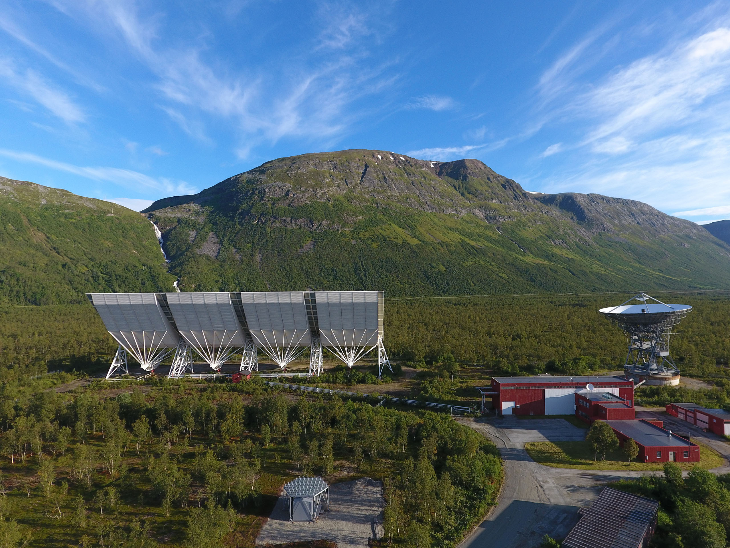 EISCAT Tromsø overview with the mountains in the background. Summer with blue sky and feather clouds.